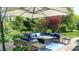 Outdoor patio set under a large umbrella, with a fire table and blue cushioned seating at 5350 Chico Grey Dr, Indianapolis, IN 46237