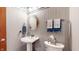 Charming powder room with pedestal sink, wainscoting, and soft lighting at 5350 Chico Grey Dr, Indianapolis, IN 46237