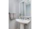Modern powder room featuring a sleek pedestal sink, mirror, and neutral color palette at 536 Lockerbie S Cir, Indianapolis, IN 46202