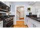 Well-equipped kitchen showcases modern appliances, granite counters, and white cabinets near stairs at 536 Lockerbie S Cir, Indianapolis, IN 46202
