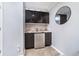 The basement wet bar features black cabinets, stainless steel appliances, and a modern backsplash at 536 Lockerbie S Cir, Indianapolis, IN 46202