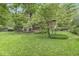Lush backyard featuring mature trees, manicured lawn, and inviting screened in porch and deck at 577 Century Oaks Dr, Zionsville, IN 46077