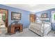 Blue bedroom with white bed, desk, and chair, featuring two pieces of wall art at 577 Century Oaks Dr, Zionsville, IN 46077