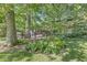 Lush, tree-filled yard showcasing a wooden deck and the house's screened-in back porch at 577 Century Oaks Dr, Zionsville, IN 46077