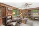 Cozy living room features wood paneling, built-in bookshelves, and large windows overlooking the yard at 577 Century Oaks Dr, Zionsville, IN 46077
