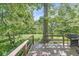 Open-air wooden deck with grill, overlooking the serene, tree-lined backyard at 577 Century Oaks Dr, Zionsville, IN 46077