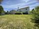 Spacious backyard ideal for entertaining, showcasing green grass, trimmed bushes, bright sunlight, and a partial rainbow at 5920 Copeland Mills Dr, Indianapolis, IN 46221