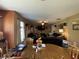 Open-concept living room with a ceiling fan and fireplace, seamless transition to the dining area and kitchen at 5920 Copeland Mills Dr, Indianapolis, IN 46221