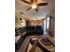 Cozy living room with a large black sectional, ceiling fan, connecting to the kitchen, perfect for relaxing and entertaining at 5920 Copeland Mills Dr, Indianapolis, IN 46221