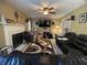 Inviting living room features a fireplace, ceiling fan, black sectional, and large windows for natural light at 5920 Copeland Mills Dr, Indianapolis, IN 46221