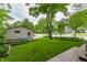 Spacious backyard with lush lawn, mature trees, and a detached garage at 595 W Poplar St, Zionsville, IN 46077
