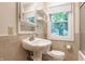 Bathroom featuring a pedestal sink, medicine cabinet, open shelving, and a window bringing in natural light at 595 W Poplar St, Zionsville, IN 46077