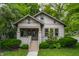 Charming home featuring a covered porch with a swing, surrounded by lush landscaping and greenery at 595 W Poplar St, Zionsville, IN 46077