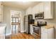 Efficient kitchen featuring stainless steel appliances, hardwood floors, and a view into the dining area at 595 W Poplar St, Zionsville, IN 46077