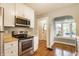 Updated kitchen featuring stainless steel appliances, white cabinets, and hardwood flooring at 595 W Poplar St, Zionsville, IN 46077