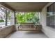 Inviting porch features a comfortable wooden swing, brick supports, and a serene outdoor view at 595 W Poplar St, Zionsville, IN 46077