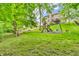 Lush backyard with a play set and swing, framed by mature trees and landscaping at 6168 Pine Bluff Dr, Avon, IN 46123