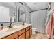 Bathroom featuring double sinks, modern black faucets, arched mirrors, and neutral-toned tile floor at 6168 Pine Bluff Dr, Avon, IN 46123