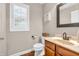 Powder room featuring a wood vanity with a sink and toilet with a window at 6168 Pine Bluff Dr, Avon, IN 46123