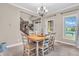 A dining room boasts a table, neutral walls, and a staircase in the background at 6168 Pine Bluff Dr, Avon, IN 46123