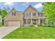 Stately two-story brick home with a well-manicured lawn and professionally landscaped front yard at 6168 Pine Bluff Dr, Avon, IN 46123