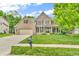 Charming brick home with a manicured lawn, mature trees and attached garage at 6168 Pine Bluff Dr, Avon, IN 46123