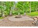 Backyard fire pit with seating for relaxing evenings under the stars with mature trees surrounding the area at 6168 Pine Bluff Dr, Avon, IN 46123