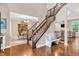 Elegant foyer features a staircase with wood and iron railings and views into dining and living areas at 6168 Pine Bluff Dr, Avon, IN 46123