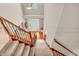 View from the top of the stairs shows the foyer with wood floors and a white front door at 6168 Pine Bluff Dr, Avon, IN 46123