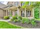 Inviting front porch with black shutters, rocking chairs, and lush landscaping at 6168 Pine Bluff Dr, Avon, IN 46123