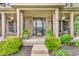 Inviting front porch with brick facade, decorative plants, rocking chairs, and a stylish front door at 6168 Pine Bluff Dr, Avon, IN 46123