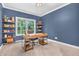 The blue office space features a wooden desk, carpeted floors and shelves for storage at 6168 Pine Bluff Dr, Avon, IN 46123
