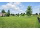 Wide shot of a well-manicured backyard featuring a pond and mature trees at 6552 Hunters S Rdg, Zionsville, IN 46077