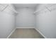 Empty walk-in closet featuring white shelving and neutral carpeting at 6552 Hunters S Rdg, Zionsville, IN 46077