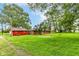 View of the expansive backyard featuring a brick home and a detached garage at 7050 N County Road 650 E, Brownsburg, IN 46112