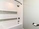 Bathtub featuring white subway tile with decorative trim and stylish black fixtures at 7050 N County Road 650 E, Brownsburg, IN 46112