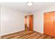 Neutral bedroom with wood-look flooring, closet, and a view through the doorway to another room at 7050 N County Road 650 E, Brownsburg, IN 46112