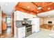 Modern kitchen with stainless steel stove, white cabinets, and access to the living room at 7050 N County Road 650 E, Brownsburg, IN 46112