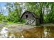 Outbuilding with a large door, surrounded by mature trees and a gravel area at 7050 N County Road 650 E, Brownsburg, IN 46112