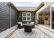 Cozy backyard patio with wicker seating around a firepit with string lights and view into kitchen at 7152 Cherry Creek Blvd, Carmel, IN 46033
