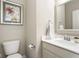 Charming half bathroom featuring a decorative mirror, white vanity, and floral artwork at 7152 Cherry Creek Blvd, Carmel, IN 46033