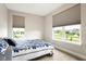 Comfortable bedroom with large windows and a blue patterned bedspread at 7152 Cherry Creek Blvd, Carmel, IN 46033