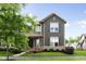 Charming two-story home with gray siding, trimmed windows, and landscaped front yard at 7152 Cherry Creek Blvd, Carmel, IN 46033