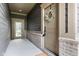 Covered front porch with wreath on front door and side-door access to the property at 7152 Cherry Creek Blvd, Carmel, IN 46033