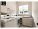Well-equipped laundry room with a washer, dryer, sink, and overhead shelving for optimal organization at 7152 Cherry Creek Blvd, Carmel, IN 46033