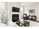 Cozy living room with fireplace, hardwood floors, tv, and comfortable seating at 7152 Cherry Creek Blvd, Carmel, IN 46033