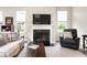 Bright living room with fireplace, white mantel, and large windows overlooking outdoors at 7152 Cherry Creek Blvd, Carmel, IN 46033