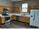 Spacious kitchen featuring wood cabinets, stainless steel appliances, and vinyl flooring at 764 Haugh St, Indianapolis, IN 46222