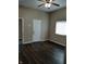 Living room with a ceiling fan, wood-look floors, and a white door at 764 Haugh St, Indianapolis, IN 46222