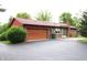 Ranch style home with brick and wood siding, red roof, and attached garage at 7931 Guion Rd, Indianapolis, IN 46268